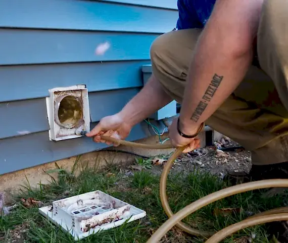 Technician cleaning an exterior dryer vent in Vienna, VA