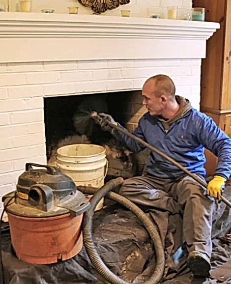 Technician cleaning a fireplace and chimney with a vacuum in Tysons, VA