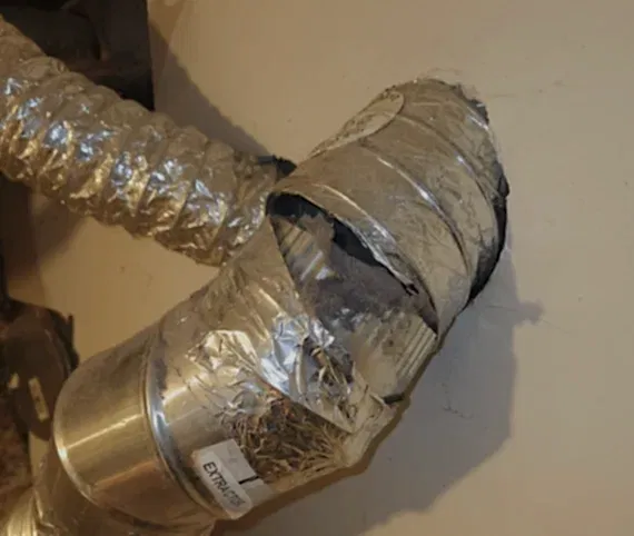Crushed and kinked foil dryer duct behind a dryer
