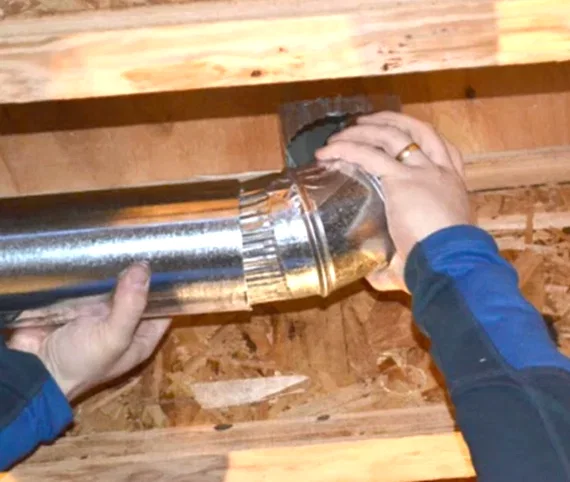 ABD technician installing rigid metal dryer vent ducting with a clamp