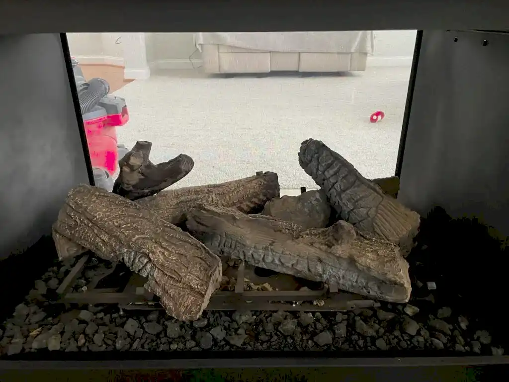 Gas log set and lava rock inside a see-through gas fireplace on an ABD service visit